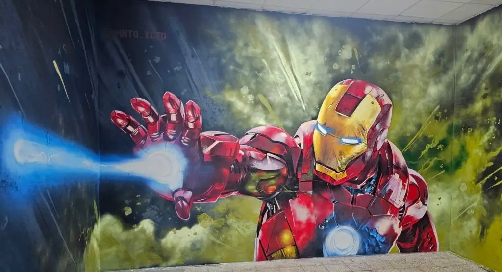 Gro&szlig;fl&auml;chiges Iron-Man-Graffiti mit leuchtendem Hand-Laser an der Wand der Lasertag Arena Braunsbedra.