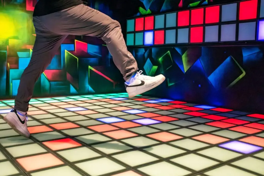 Spieler springt &uuml;ber das interaktive LED-Bodenfeld des Lightjumper-Spiels in der Lasertag Arena Braunsbedra.